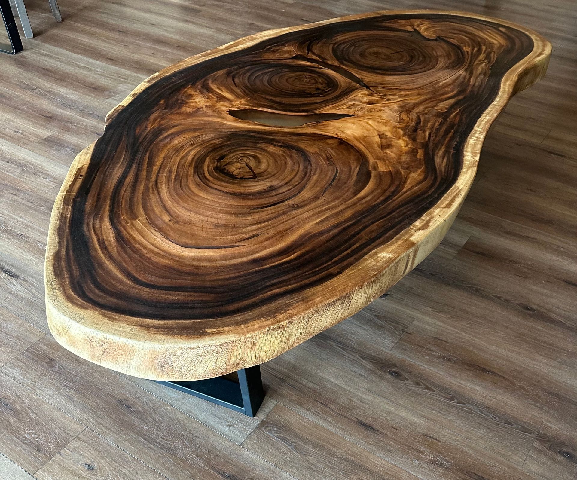 A large piece of wood is sitting on a wooden floor.