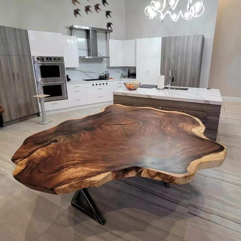A kitchen with a large wooden table in the middle of it.