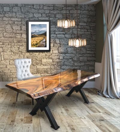 A dining room with a wooden table and chairs and a brick wall.