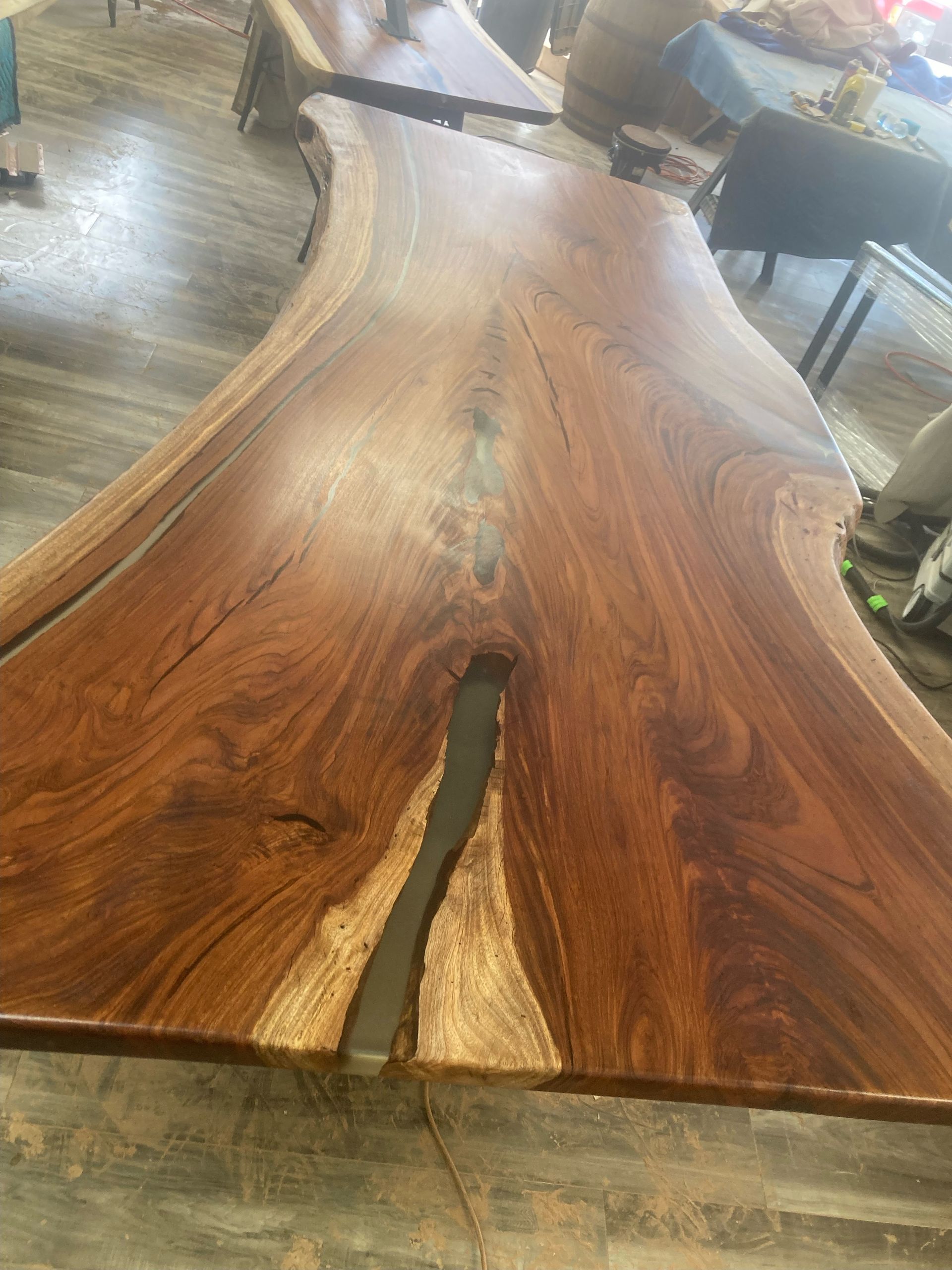 A wooden table with a hole in the middle of it is sitting on a wooden floor.