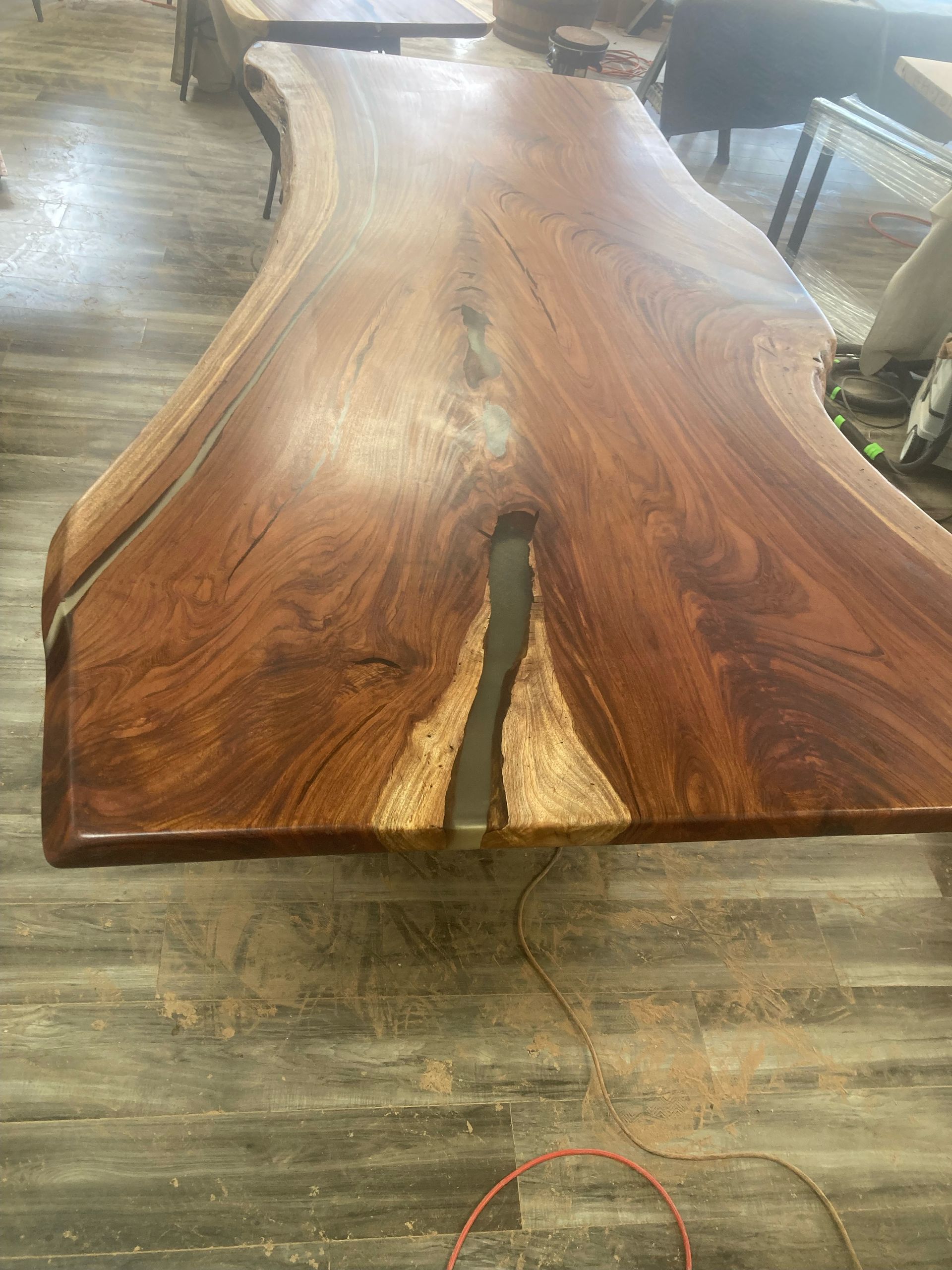 A wooden table with a hole in the middle of it is sitting on a wooden floor.