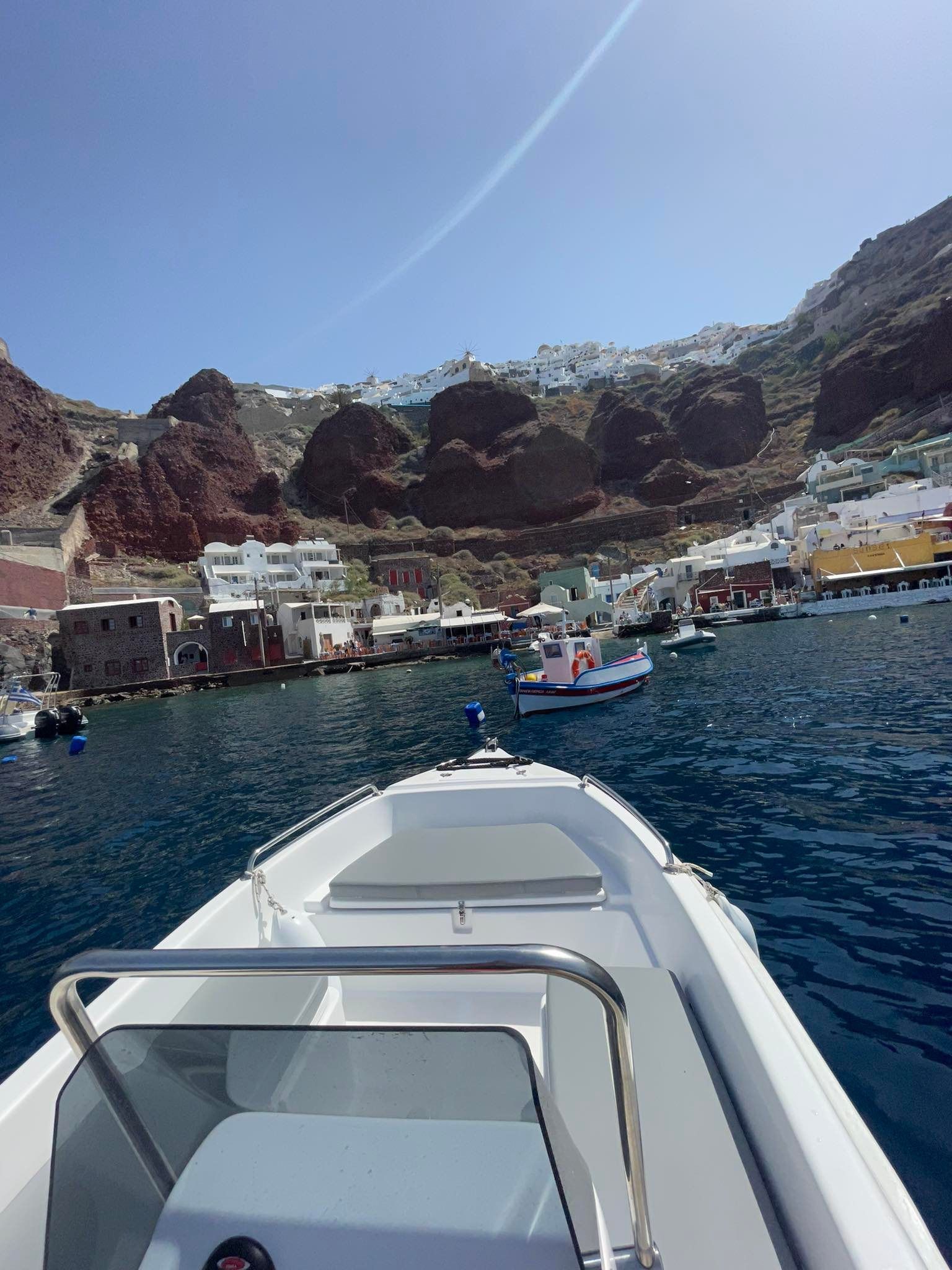 A boat is floating in the water with mountains in the background