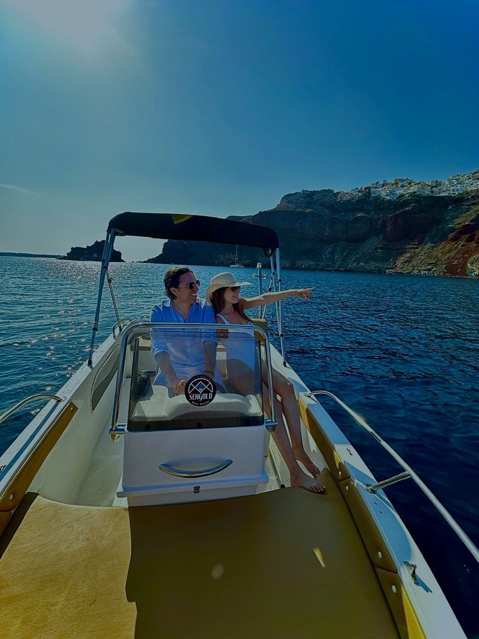 Couple on a SEAGOLD rental boat exploring Santorini coastline
