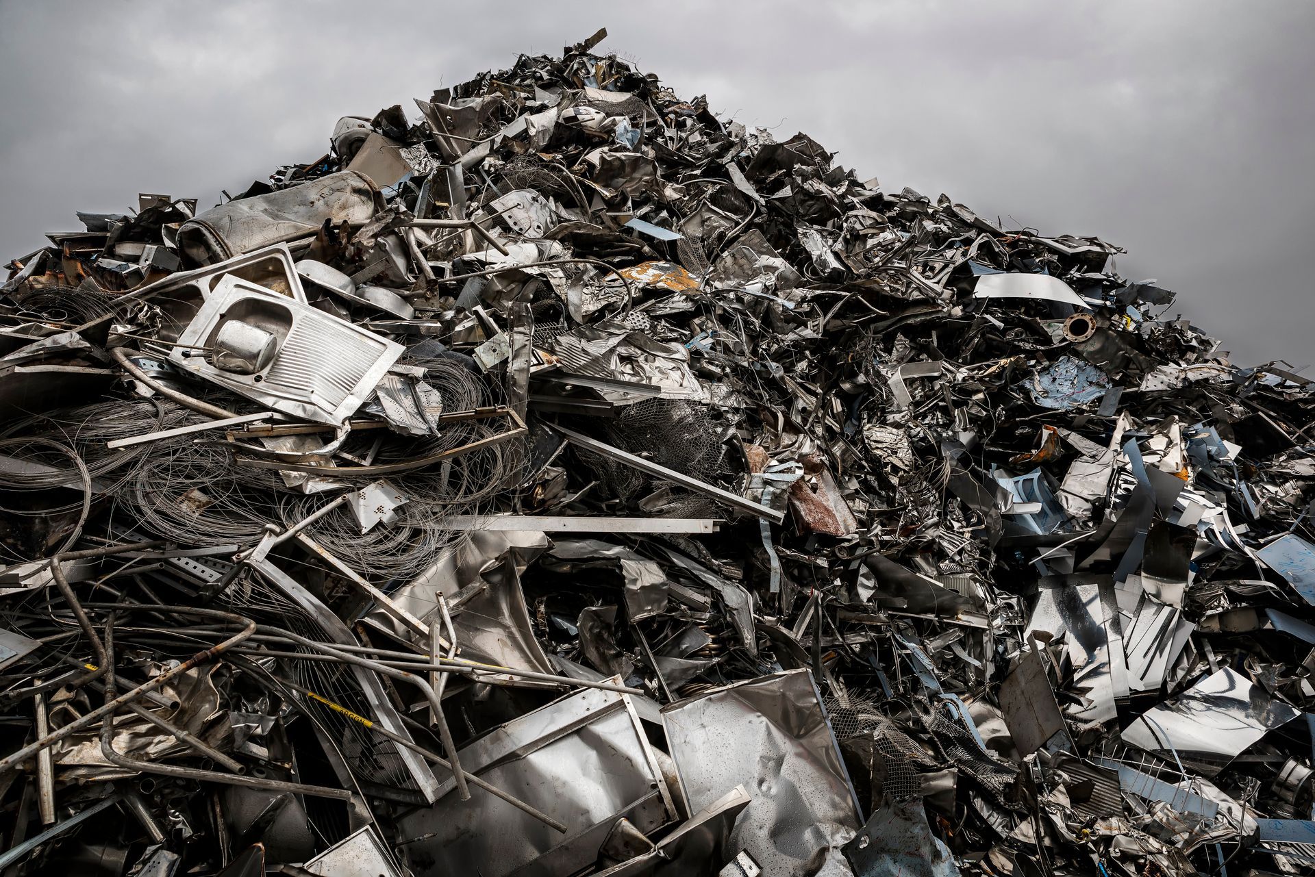 Towering mountain of steel scrap, stacked high and ready for recycling operations.