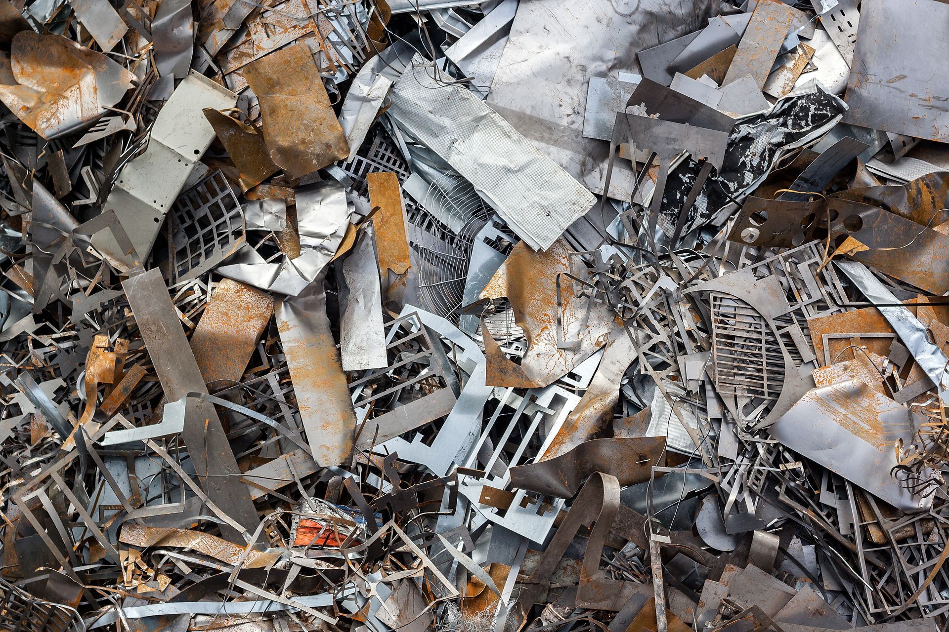 Pile of scrap metal consisting of various rusted and silver-colored metal sheets, rods, and grates. Pile of scrap metal consisting of various rusted and silver-colored metal sheets, rods, and grates.