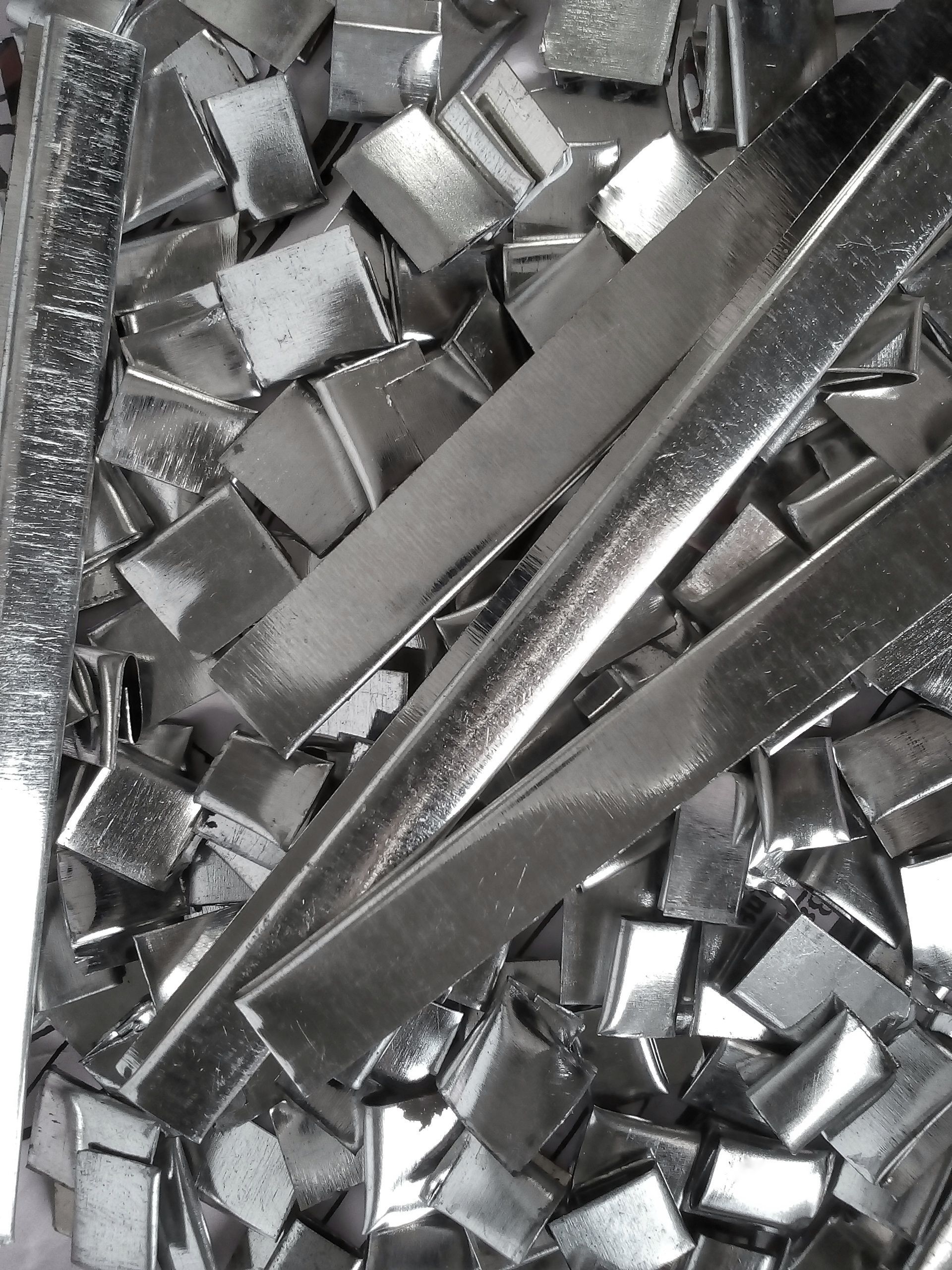 A pile of small aluminum metal pieces from unused industrial waste material. A pile of small aluminum metal pieces from unused industrial waste material.