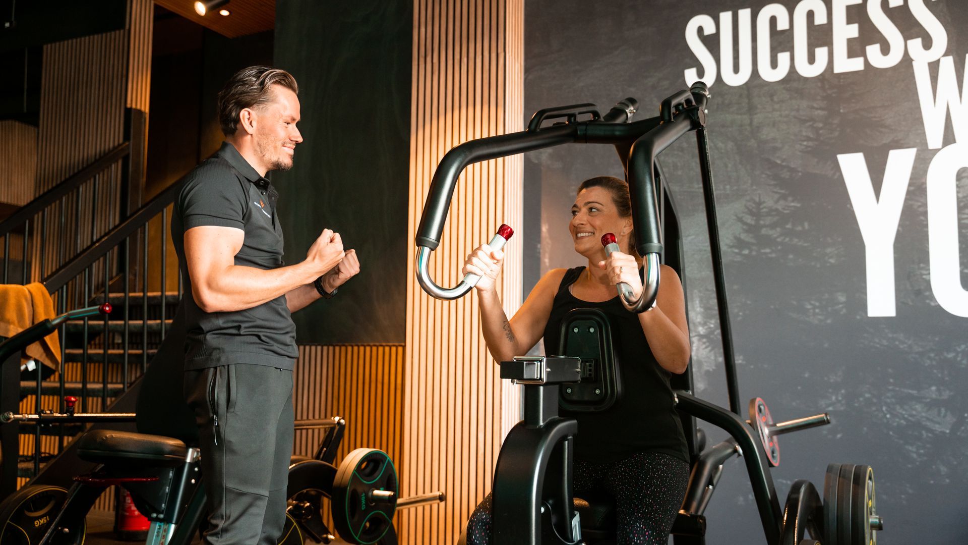 Twee vrouwen in sportkleding doen zittende twistyogahoudingen in een zonnige studio.