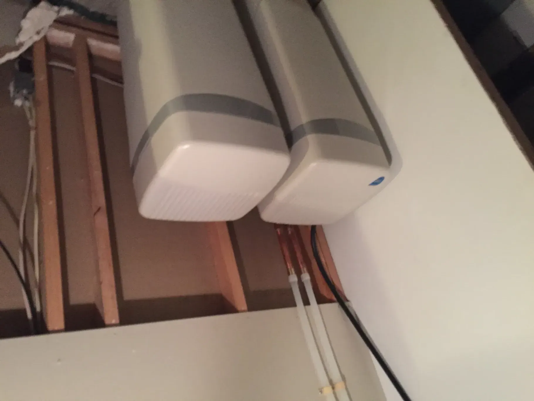 Two white boxes are hanging from the ceiling in a room