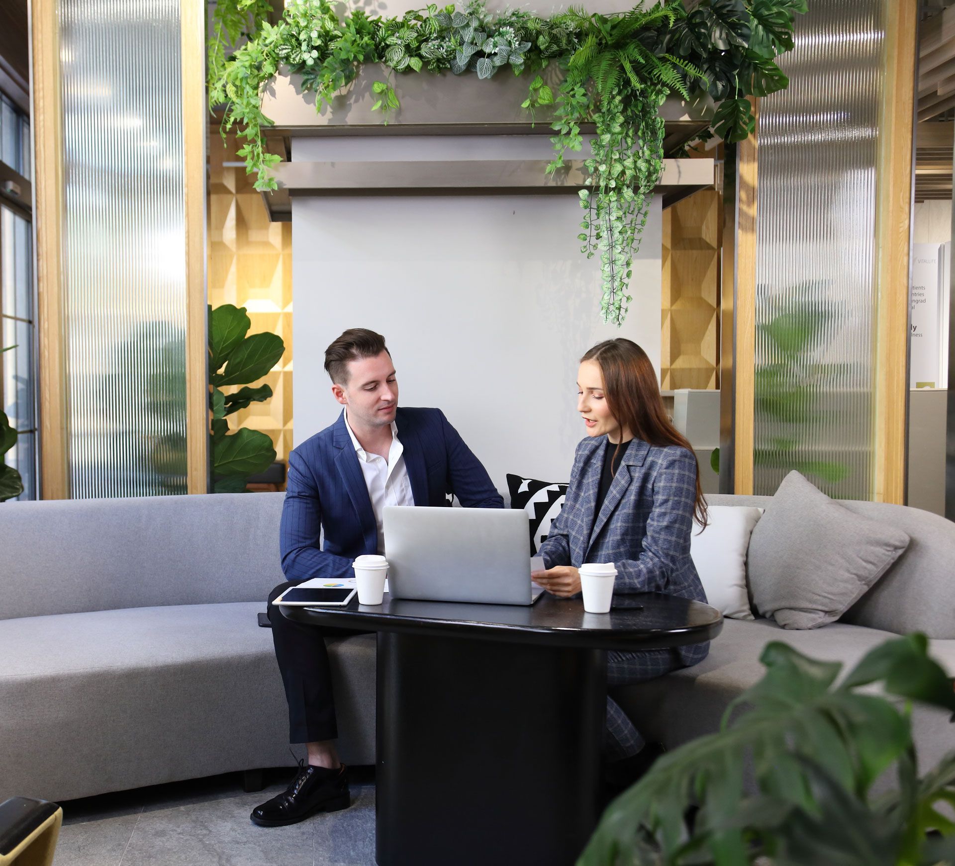 A man and a woman are sitting at a table with a laptop
