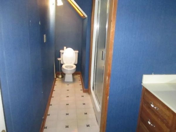 A bathroom with a toilet and a walk in shower