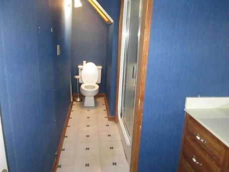 A bathroom with a toilet and a walk in shower