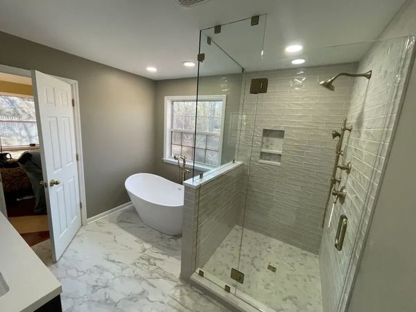 A bathroom with a tub and a walk in shower.