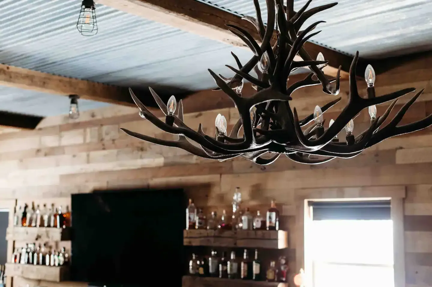 A chandelier made of antlers is hanging from the ceiling of a room.
