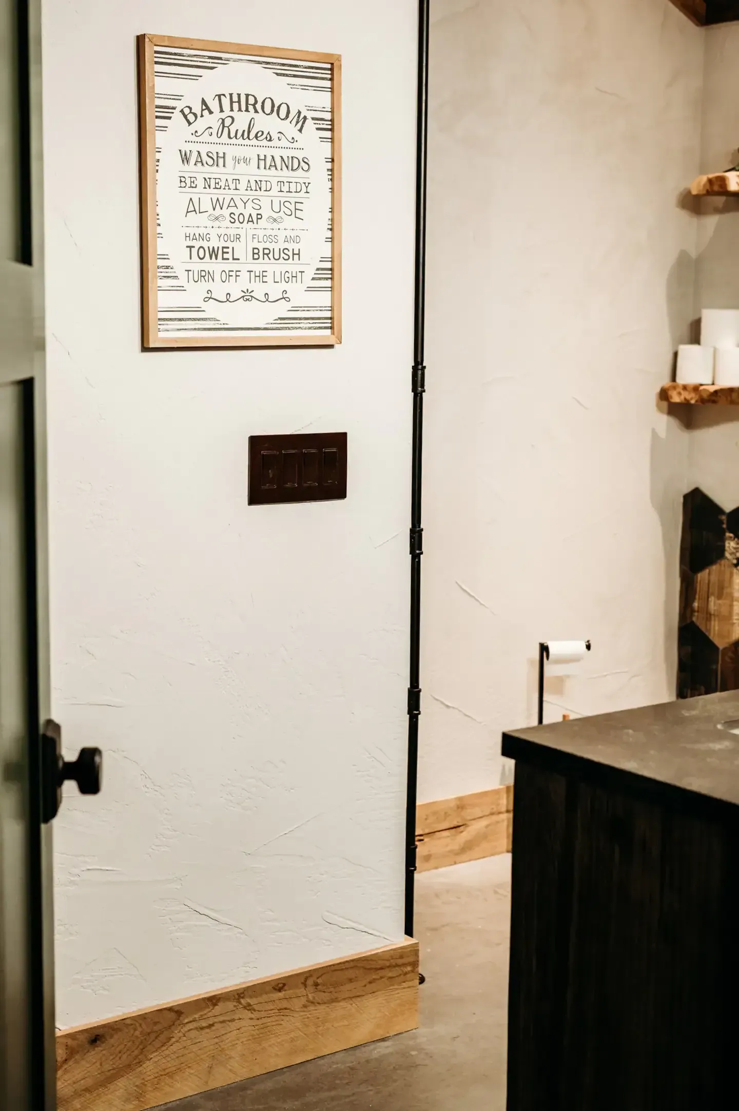 A bathroom with a sign on the wall above the door.