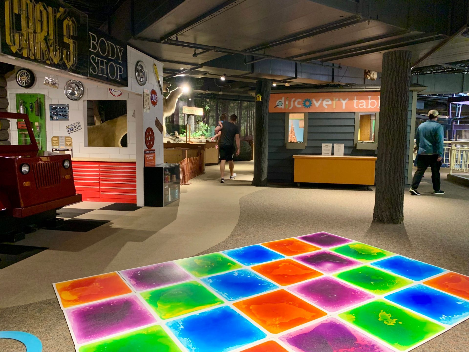 A colorful dance floor in a museum with a red truck in the background