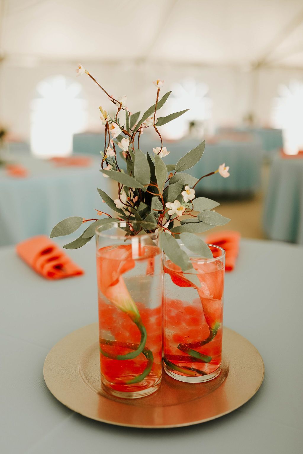 Two glasses filled with watermelon slices and flowers on a table.