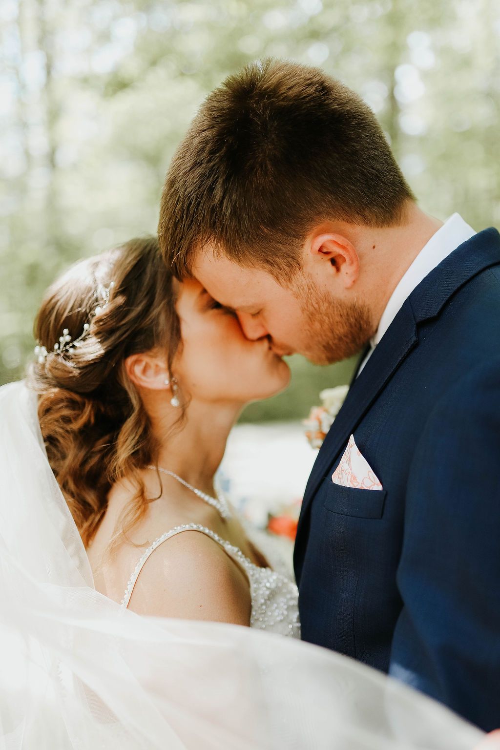 A bride and groom are kissing each other on their wedding day.