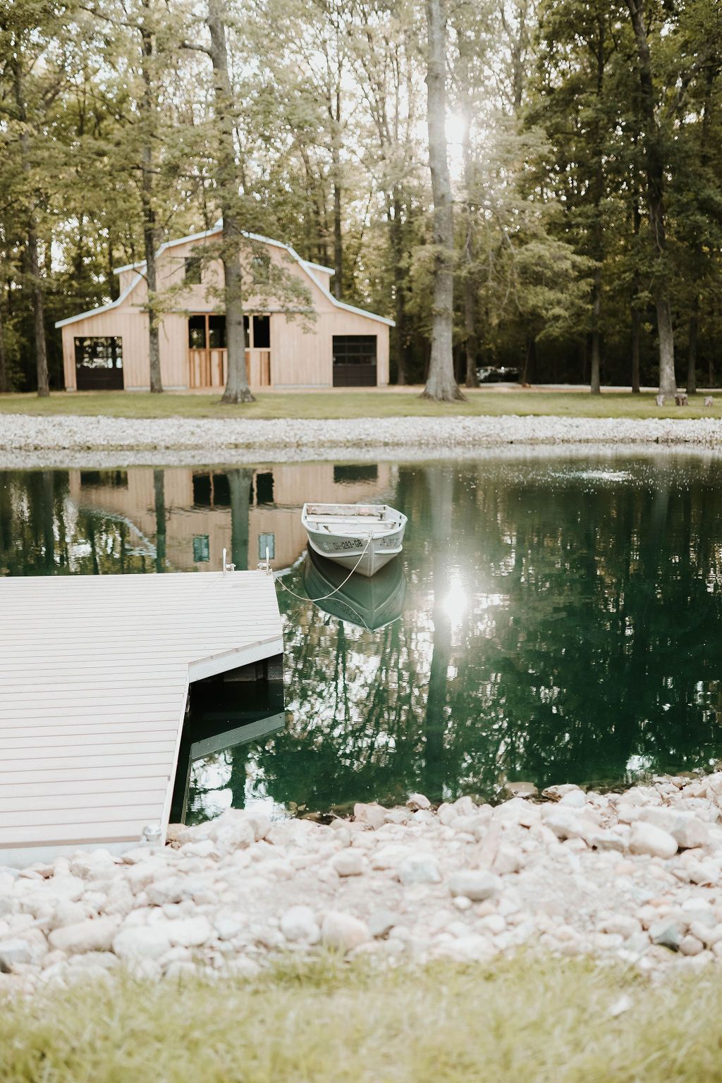 A boat is floating on top of a pond next to a dock.