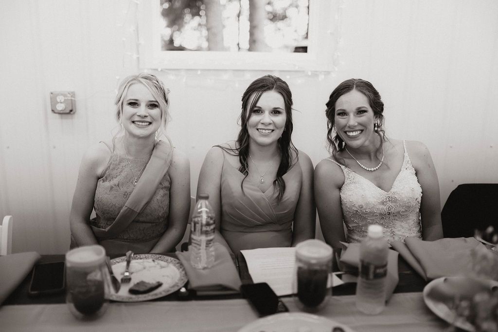 A black and white photo of three women sitting at a table.