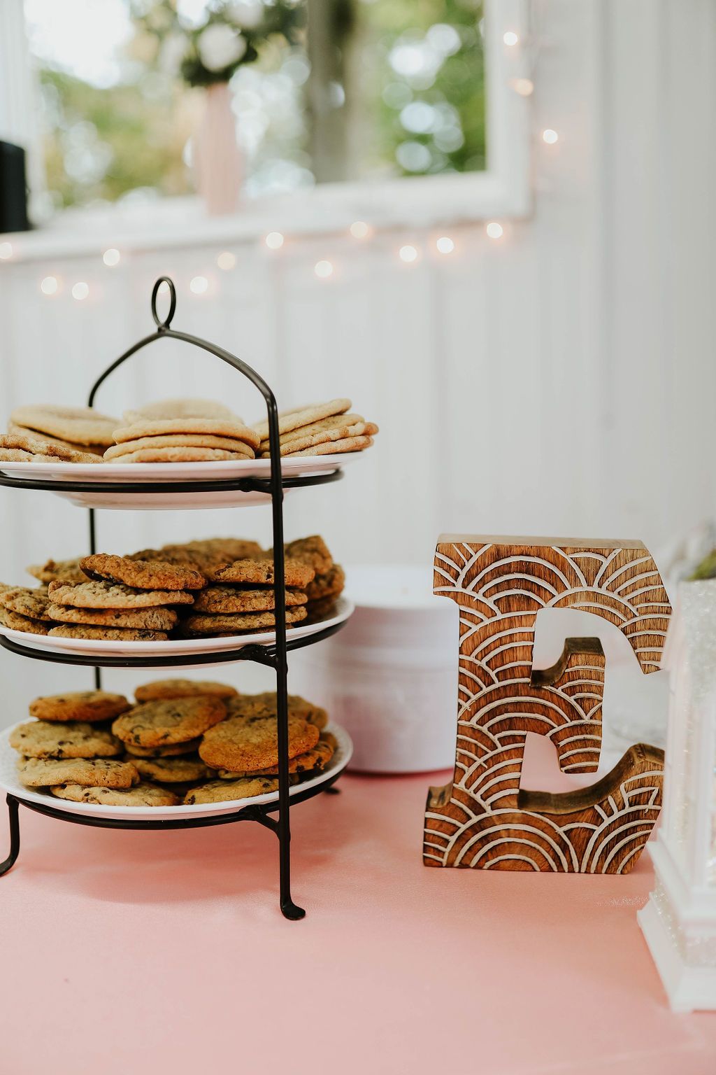 Three trays of cookies are sitting on a table next to a letter e.