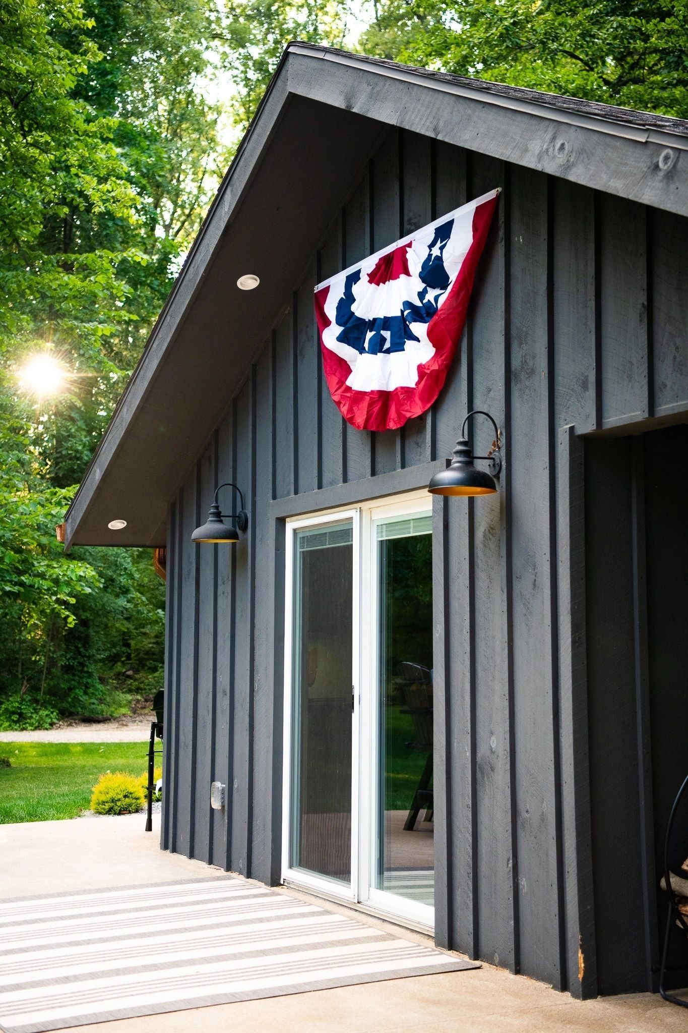 A black house with a red , white and blue flag hanging from the roof.