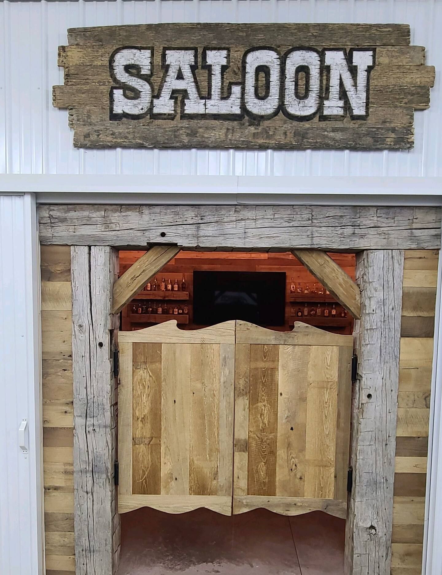 A saloon with wooden doors and a sign above it