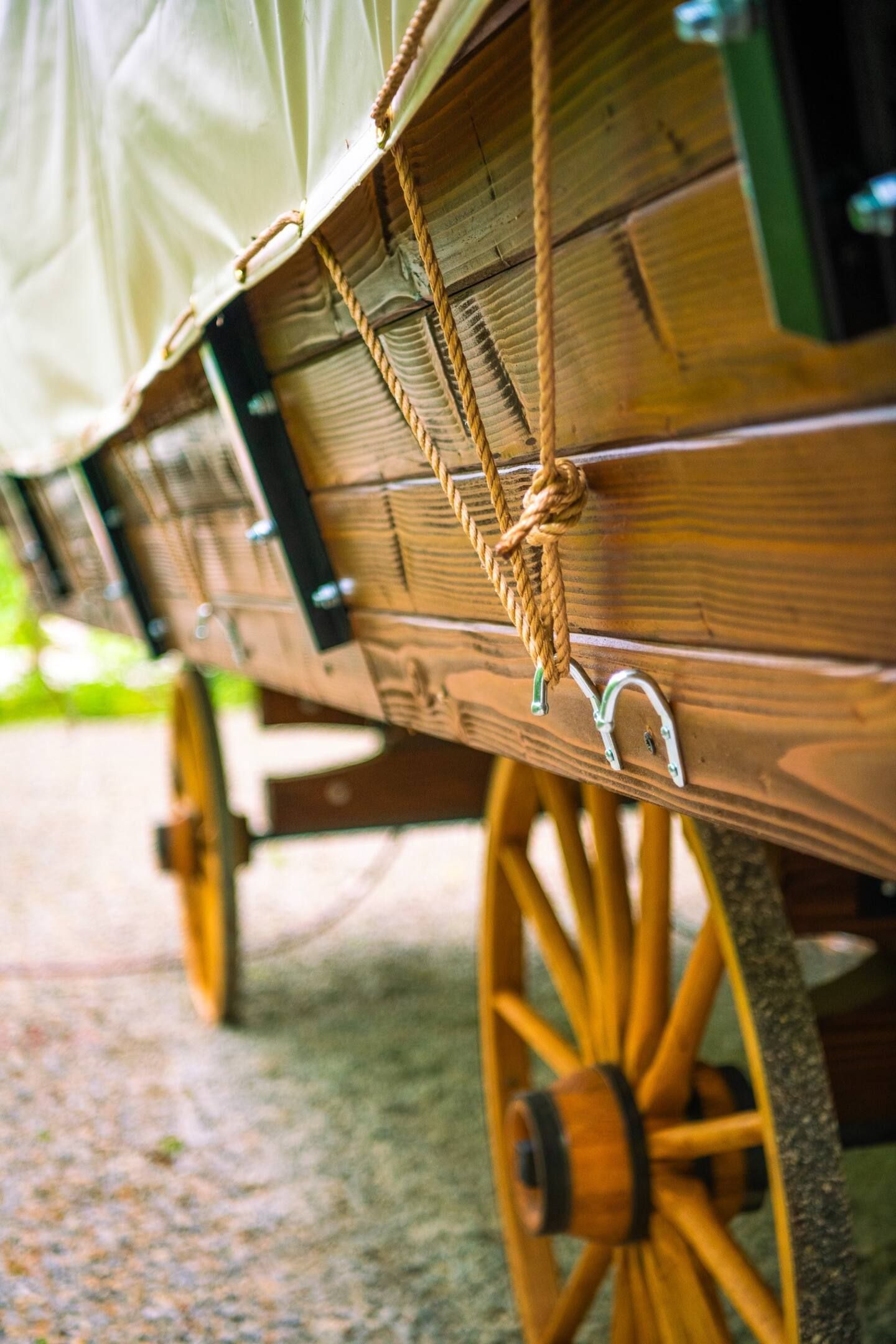 A close up of a wooden wagon with ropes attached to it.
