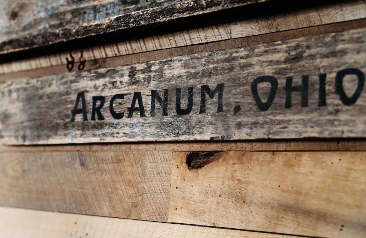 A close up of a wooden sign that says arcanum ohio on it.