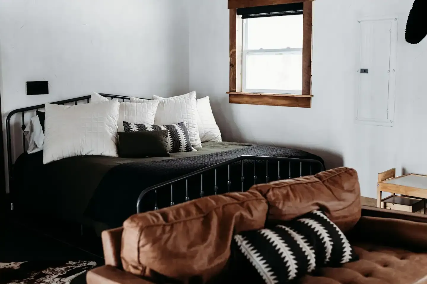A bedroom with a bed , couch , and window.