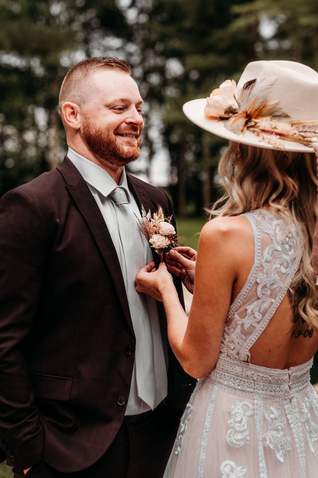 Bride and groom smiling and holding hands at an outdoor wedding