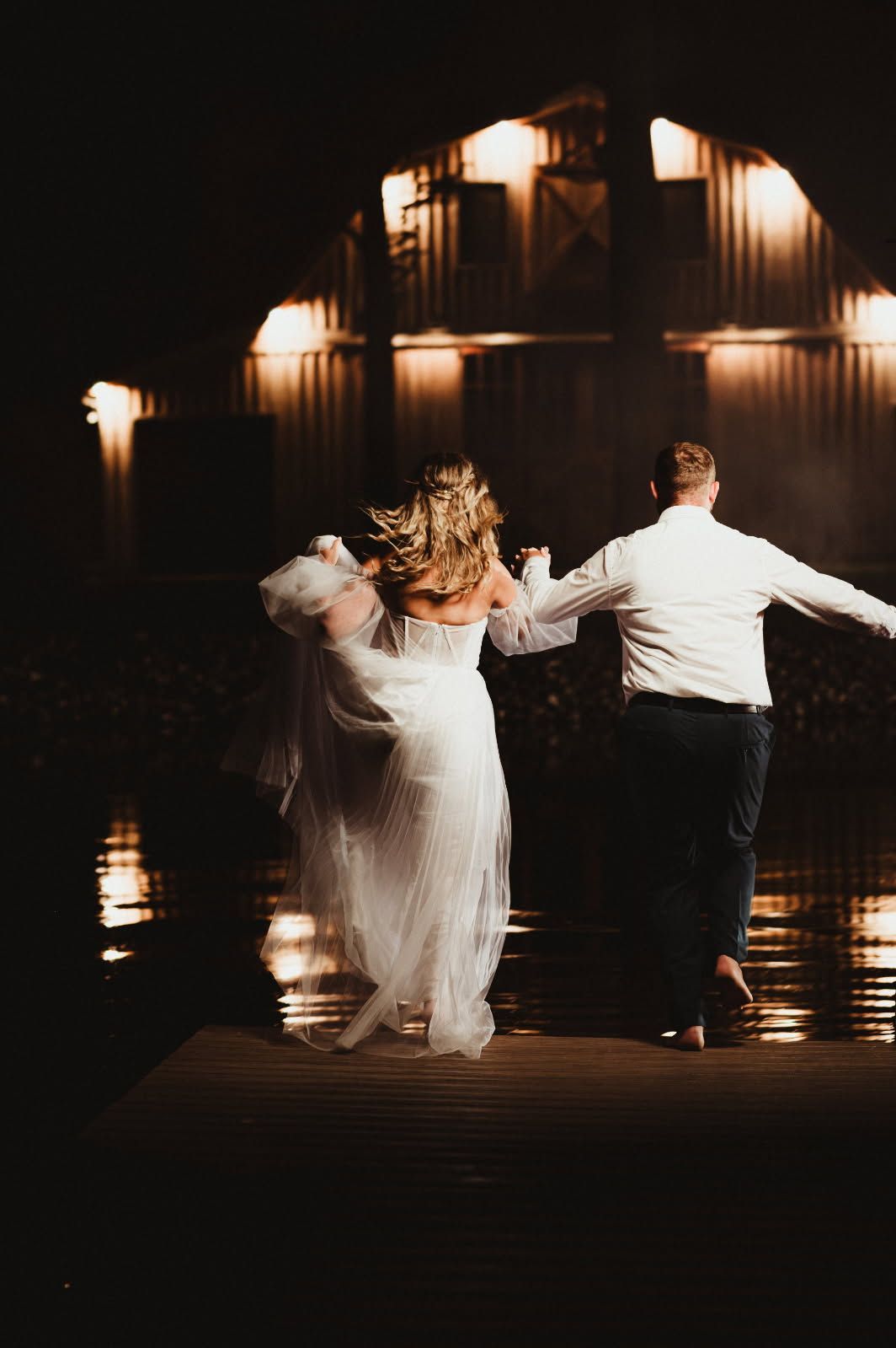 Couple dancing under warm lights in a dark, reflective venue