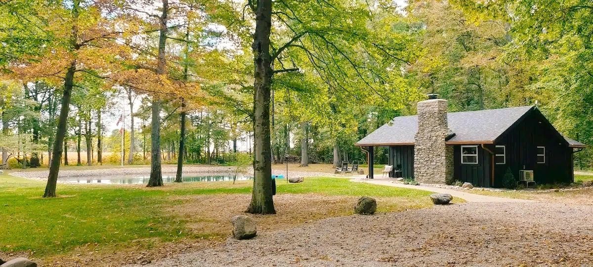 A small house in the middle of a forest with a fireplace.