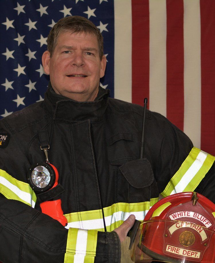 A fireman holding a helmet that says fire dept