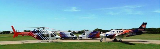 A helicopter and a plane are parked on a runway