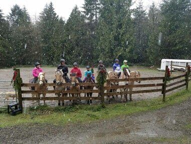 Riders on horses in by arena fence - Horse riding lessons in Olalla WA