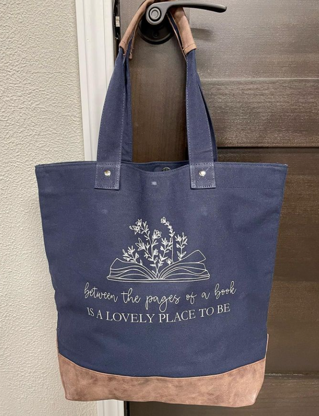 A blue tote bag is hanging on a door handle.