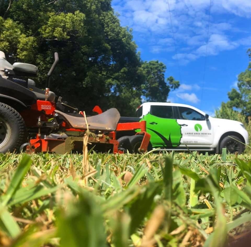 A Red Lawn Mower is Parked Next to a White Truck — 4WD Slashing & Large Area Mowing In Alstonville, NSW
