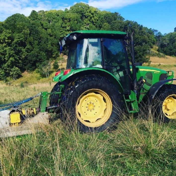 A Green and Yellow Tractor is Parked in a Grassy Field — 4WD Slashing & Large Area Mowing In Alstonville, NSW