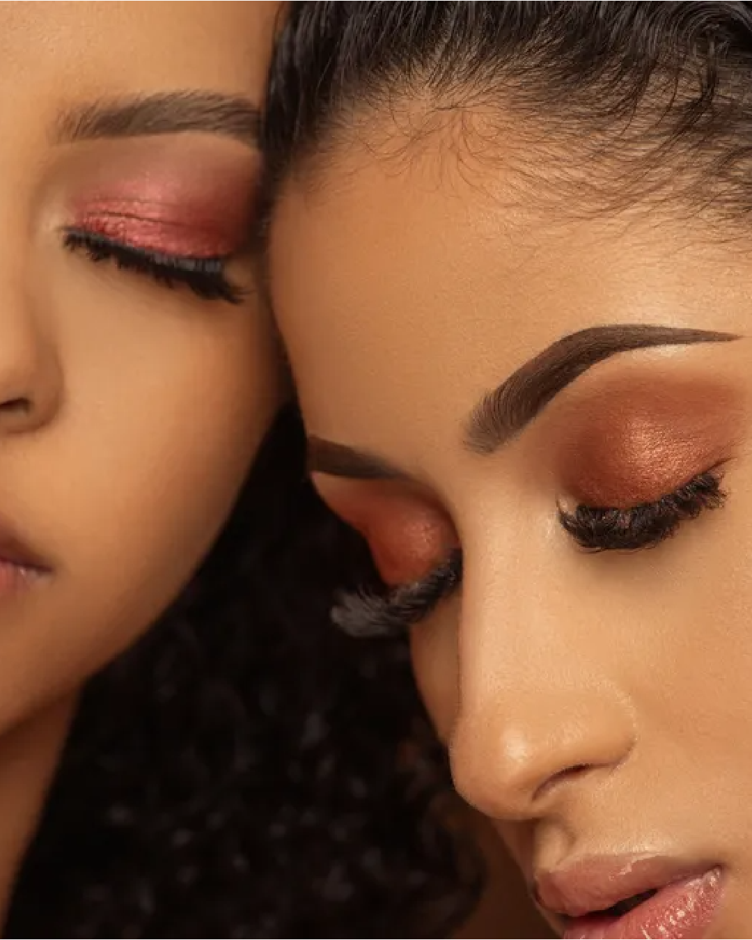 Eine Nahaufnahme der Gesichter zweier Frauen mit geschlossenen Augen.