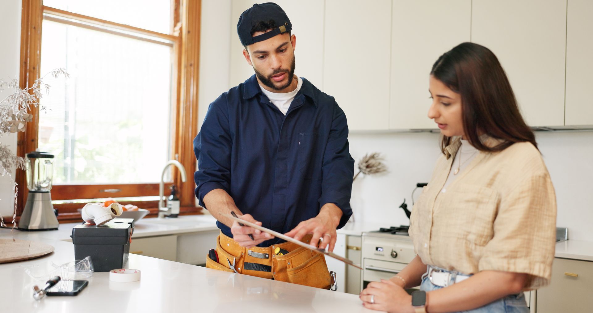 Woman and handyman with paper on clipboard for maintenance service, information and repairs. Woman and handyman with paper on clipboard for maintenance service, information and repairs.