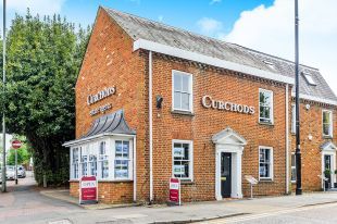 A large brick building with a sign on the side of it that says curchods.