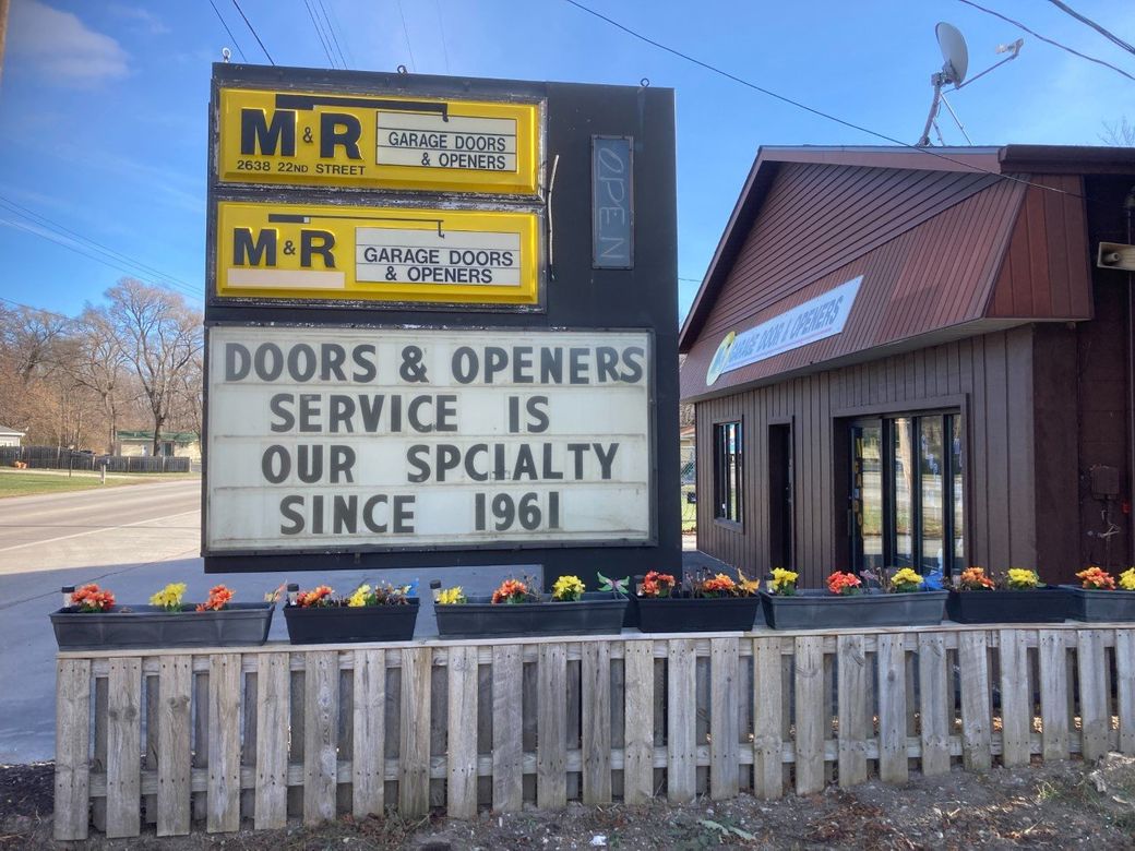 A sign that says doors and openers service is our specialty since 1961