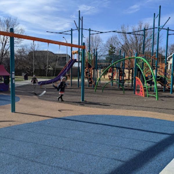 A girl is swinging on a swing set in a playground