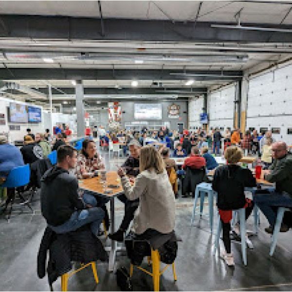 A group of people are sitting at tables in a large room.