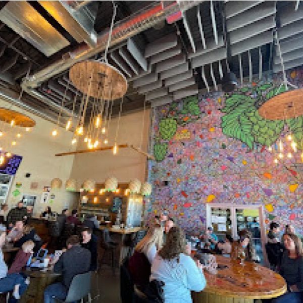A restaurant filled with tables and chairs and a neon sign