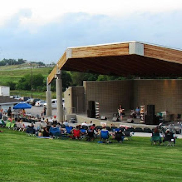 A group of people are sitting in chairs in front of a stage.