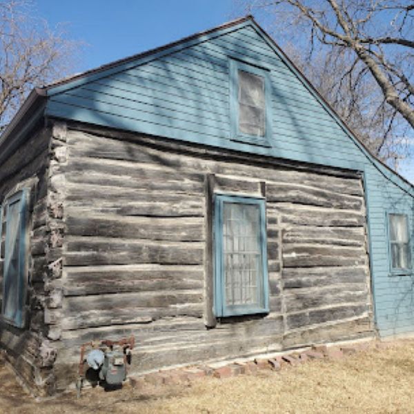 A log cabin with a blue roof and blue windows