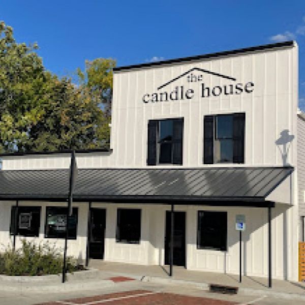 A white building with a sign that says the candle house