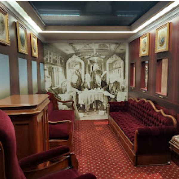 A room with a couch and chairs and a picture on the wall