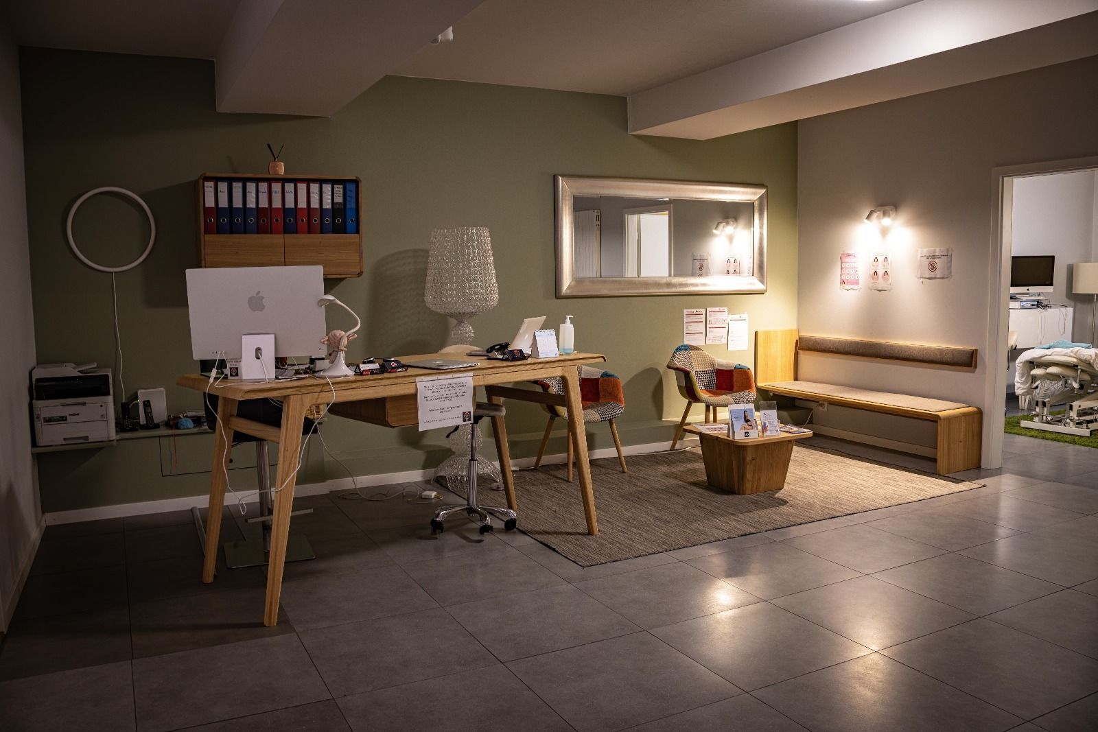 Un bureau avec un bureau, un banc et d'autres meubles, avec une palette de couleurs vertes et grises atténuées.